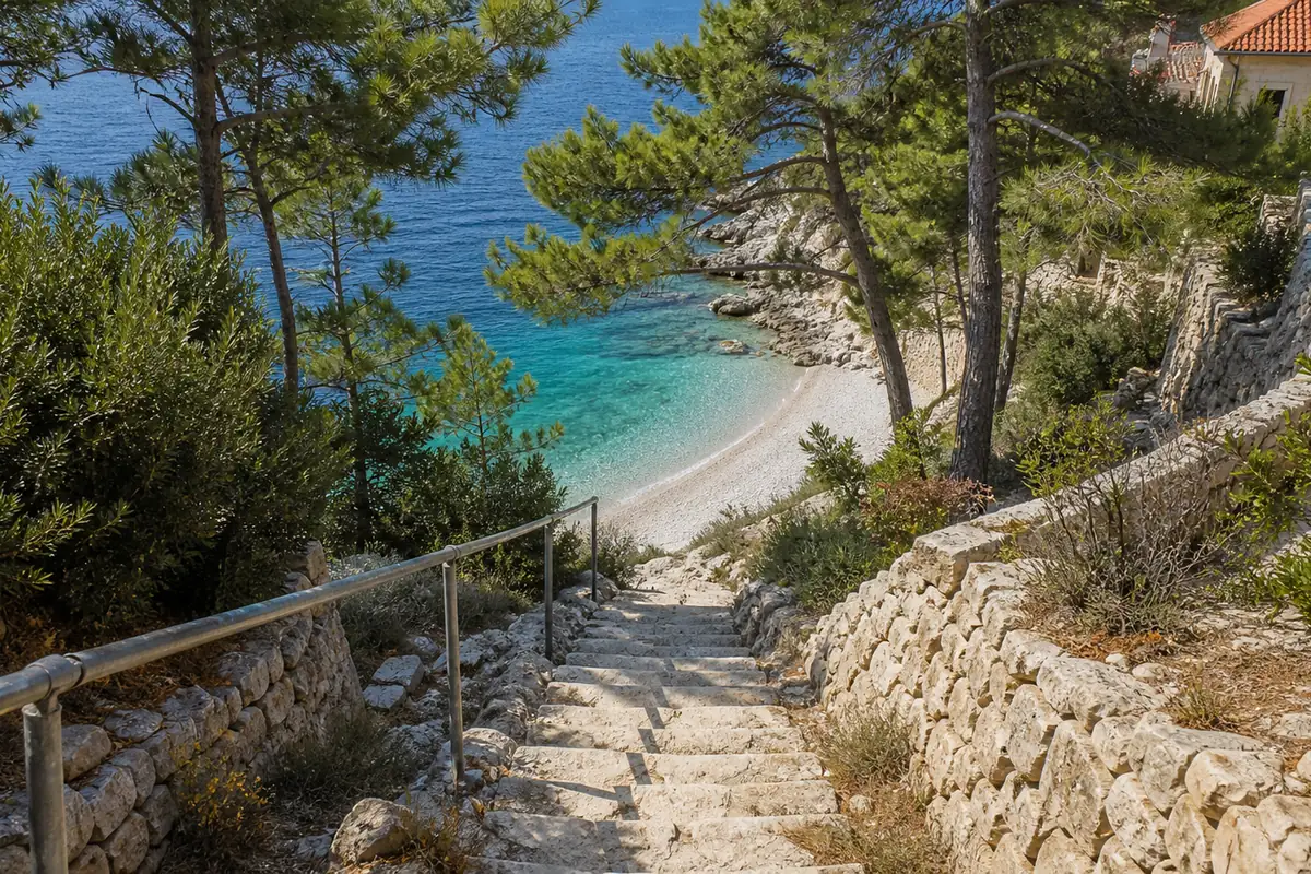 Steile Steintreppe von einem Ferienhaus hinunter zu einer Kiesbucht