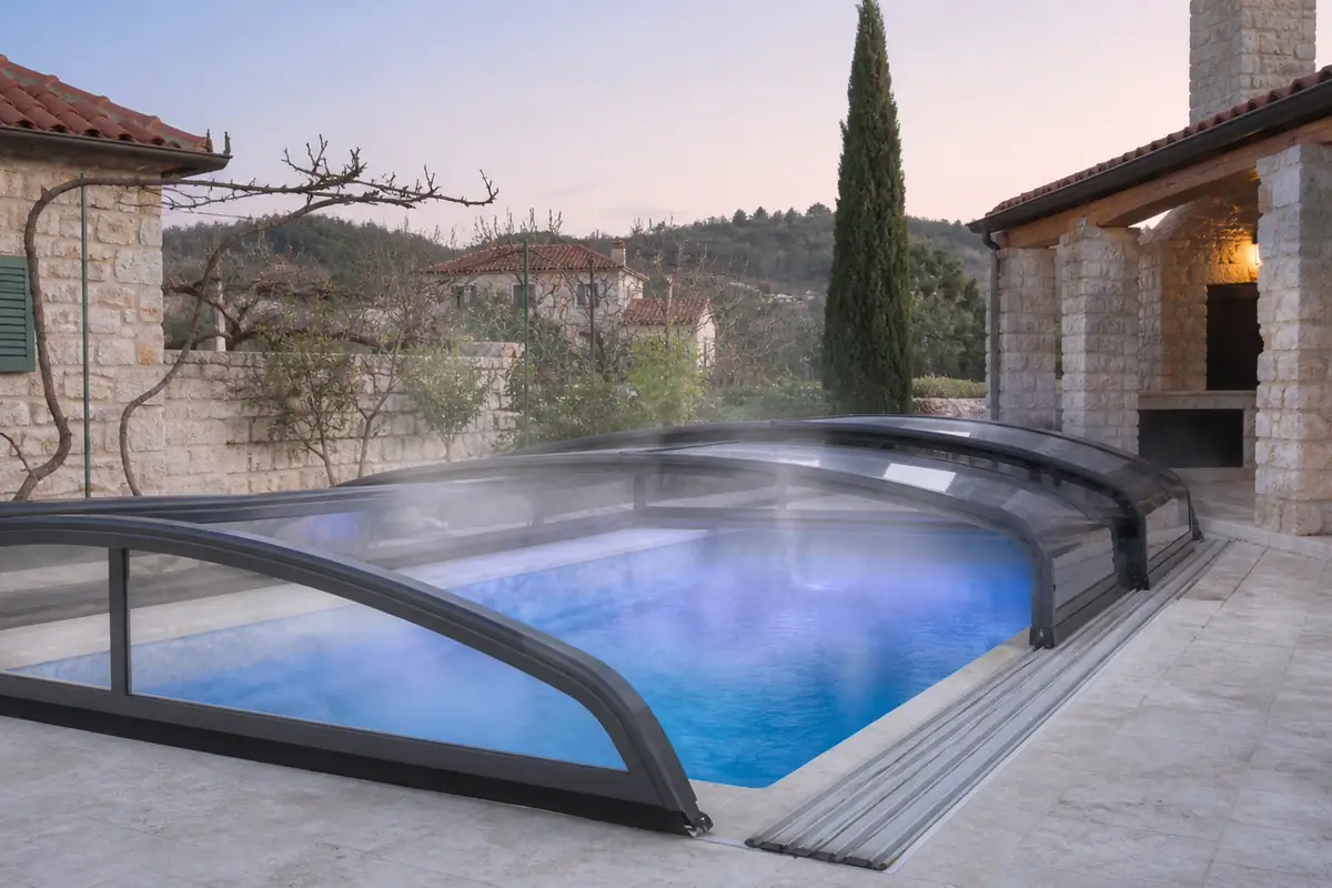 Pool mit aufgeschobener Überdachung an einem Steinhaus im Frühjahr