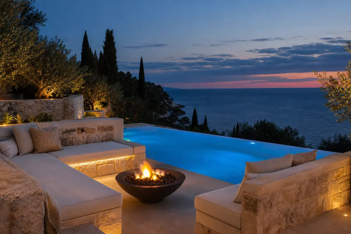 Beleuchtete Außenlounge einer Luxusvilla mit Pool in der Abenddämmerung